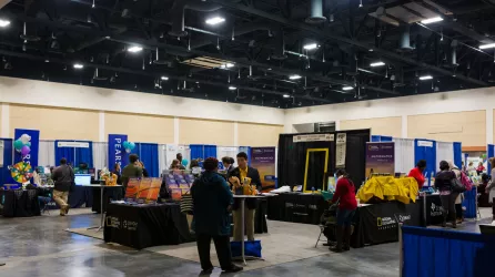 Exhibit hall with vendors for math conference.