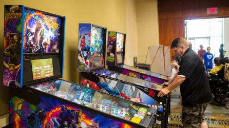 man playing a spider man pinball machine